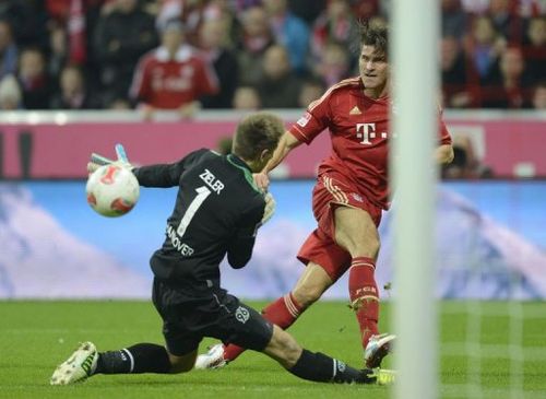 Bayern Munich's striker Mario Gomez (R) scores the fifth goal for Munich against Hanover's goalkeeper Ron-Robert Zieler