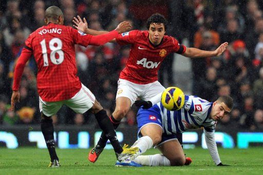 Manchester United&#039;s Brazilian defender Rafael (C) and English forward Ashley Young (L) challenge QPR&#039;s Adel Taarabt