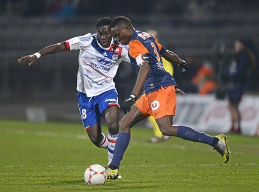 Lyon&#039;s forward Bafetimbi Gomis (L) fights for the ball with Montpellier&#039;s defender Mapou Yanga-Mbiwa