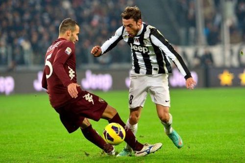 Juventus' midfielder Claudio Marchisio (R) clashes with Torino's defender Valerio Di Cesare