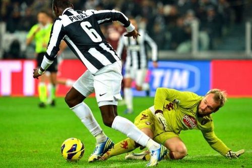 Juventus' midfielder Paul Pogba (L) fights for the ball with Torino's goalkeeper Jean Francois Gillet