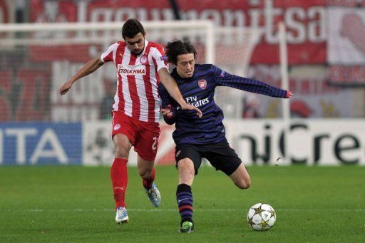 Olympiakos Giannis Maniatis fights for the ball with Arsenal&#039;s Tomas Rosicky (R)