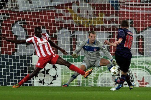 Olympiakos&#039; goalie Roy Carrol eyes the ball after a shot by Arsenal&#039;s Aaron Ramsey