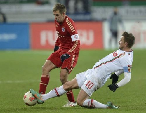 Bayern Munich's defender Philipp Lahm (L) and Augsburg's midfielder Daniel Baier challenge for the ball