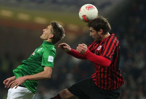 Frankfurt's Heiko Butscher (R) and Bremen's Nils Petersen jump for the ball