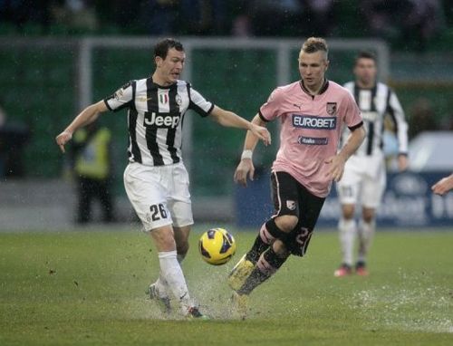 Juventus's Stephan Lichtsteiner (L) is challenged by Palermo's defender Jasmin Kurtic