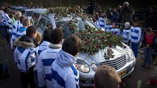 Members of SC Buitenboys lay roses on a hearse carrying the body of linesman Richard Nieuwenhuizen