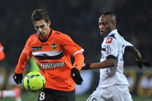 Sochaux&#039;s forward Ishmael Yartey (R) vies with Lorient&#039;s French midfielder Maxime Barthelme (L)