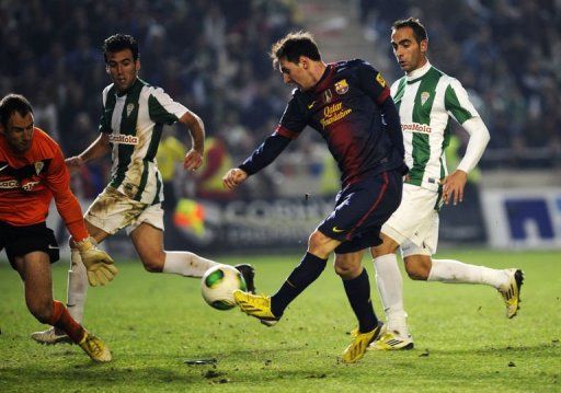 Barcelona&#039;s Argentinian forward Lionel Messi (2nd R) vies with Cordoba&#039;s goalkeeper Mikel Saizar (L)