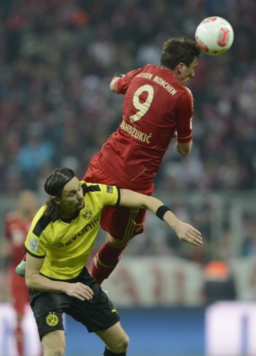 Bayern striker Mario Mandzukic outjumps Dortmund's Neven Subotic during the German Bundesliga match on December 1, 2012