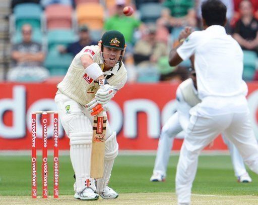 Australian batsman David Warner hits the ball back to Sri Lankan bowler Nuwan Kulasekara in Hobart on December 14, 2012