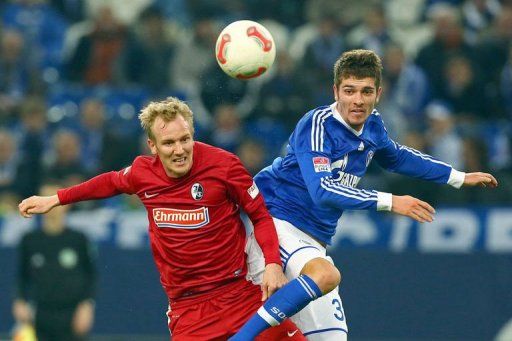 Freiburg&#039;s Jan Rosenthal (L) and Schalke&#039;s Roman Neustaedter fight for the ball on December 15, 2012