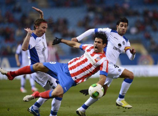 Atletico Madrid&#039;s Diego da Silva Costa (C) fights for the ball with Getafe&#039;s players, on December 12, 2012
