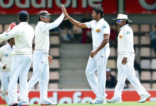 Sri Lanka&#039;s Chanaka Welegedara (2/R) is congratulated by teammates after taking a wicket on December 17, 2012