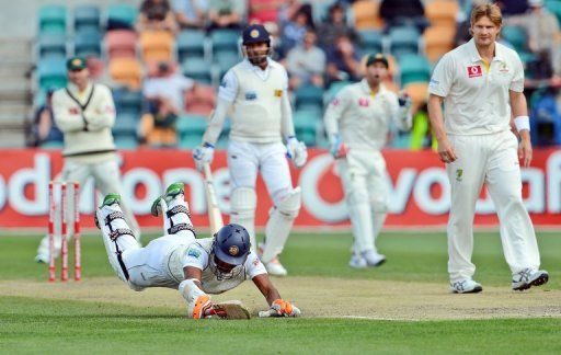 Sri Lanka batsman Dimuth Karunaratne dives to beat a throw at the wicket in Hobart on December 17, 2012