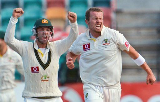 Australia&#039;s Peter Siddle (R) celebrates with Phil Hughes after dismissing Thilan Samaraweera on December 18, 2012