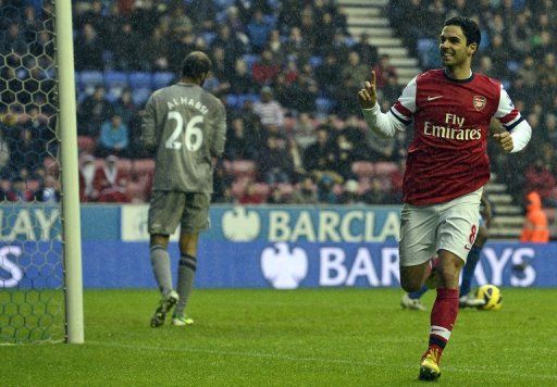 Arsenal&#039;s midfielder Mikel Arteta (right) celebrates scoring the opening goal in Wigan, England, December 22, 2012