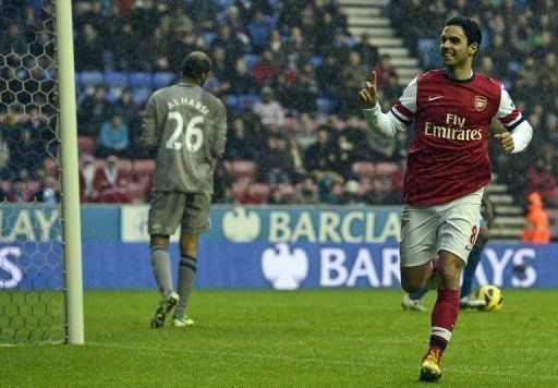 Arsenal&#039;s midfielder Mikel Arteta (R) celebrates scoring the opening goal in Wigan, England on December 22, 2012