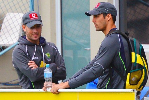 Michael Clarke (L) speaks with Mitchell Johnson during a training session in Hobart, on December 13, 2012