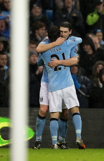 City midfielder Gareth Barry celebrates with David Silva after scoring his injury-time winner on December 22, 2012