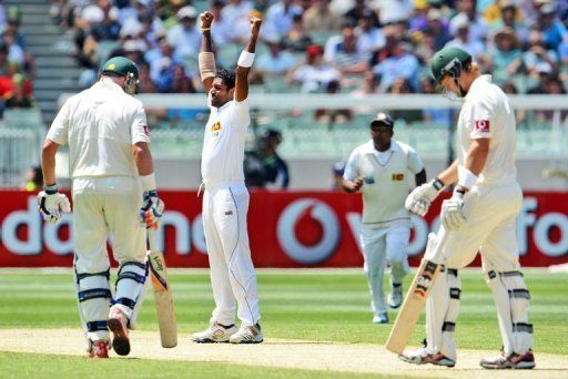 Dhammika Prasad celebrates dismissing Shane Watson (R) on the second day of the second Test on December 27, 2012