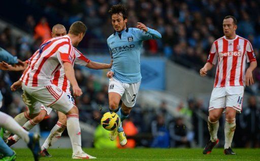 Manchester City midfielder David Silva (C) runs at the Stoke City defence at the Etihad Stadium on January 1, 2013