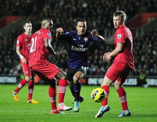 Theo Walcott (C) skips past Southampton's Guly Do Prado (L) and James Ward-Prowse at St Mary's Stadium on January 1, 2013