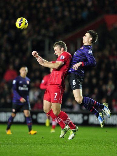 Southampton striker Rickie Lambert (L) shields the ball from Laurent Koscielny on January 1, 2013