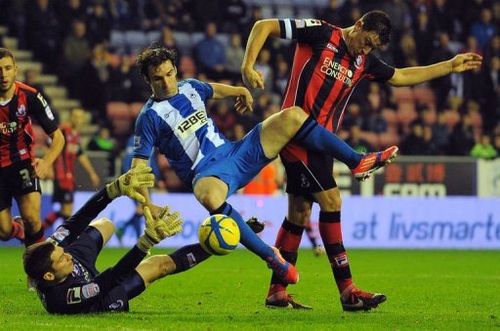 Wigan's Mauro Boselli (C) clashes with Bournemouth's Tommy Elphick (R) and Shwan Jalal in Wigan on January 5, 2013