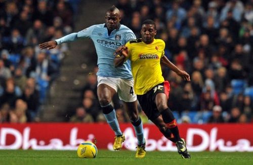 Manchester City's Mario Balotelli (L) clashes with Watford's Geoffrey Mujangi Bia in Manchester on January 5, 2013