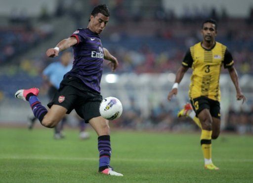 Marouane Chamakh (L) tees up a shot during an Arsenal friendly against Malaysia in Kuala Lumpur on July 24, 2012
