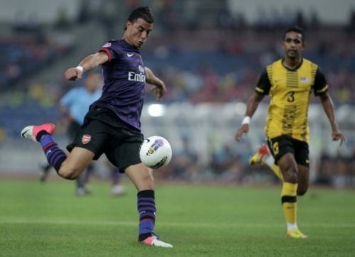 Marouane Chamakh (L) tees up a shot during an Arsenal friendly against Malaysia in Kuala Lumpur on July 24, 2012