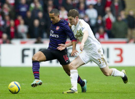 Arsenal&#039;s Theo Walcott (left) and Swansea City&#039;s Ben Davies at The Liberty Stadium in Swansea, Wales on January 6, 2013