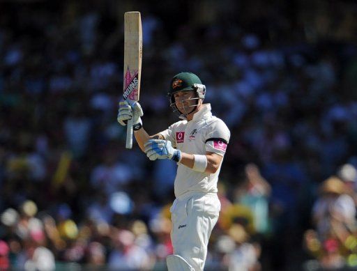Australia&#039;s Michael Clarke raises his bat after reaching his 50 during the 3rd Test against Sri Lanka on January 4, 2013