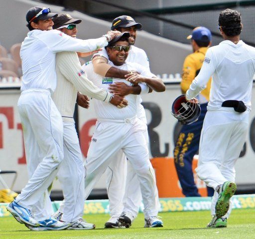 Sri Lanka&#039;s Rangana Herath (C) celebrates after dismissing Michael Hussey during the 2nd Test on December 27, 2012