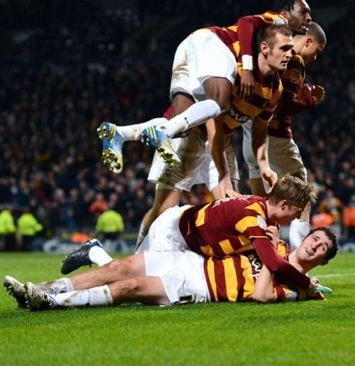 Bradford City defender Carl McHugh (bottom) celebrates with teammates after scoring the third goal on January 8, 2013