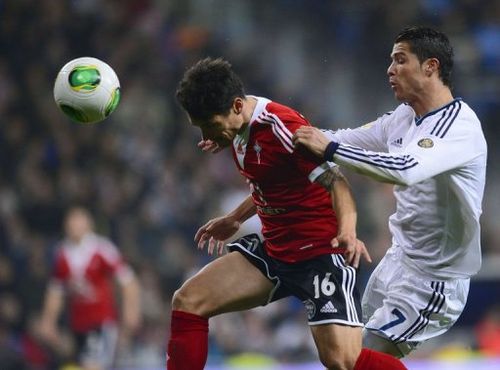 Real Madrid's Portuguese forward Cristiano Ronaldo (R) vies with Celta's defender Carlos Bellvis on January 9, 2013