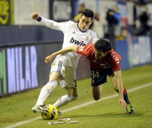 Real Madrid&#039;s Jose Maria Callejon (L) fights for the ball with Osasuna&#039;s Alejandro Arribas in Pamplona, January 12, 2013