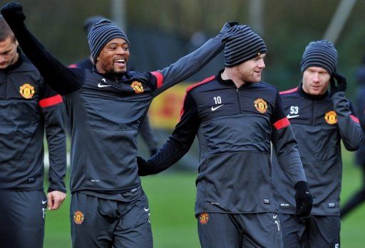 Manchester United&#039;s Patrice Evra (L) and Wayne Rooney (2nd R), pictured during a training session, on December 4, 2012