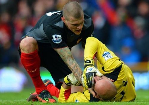 Liverpool's Martin Skrtel attends to injured goalkeeper Pepe Reina at Old Trafford on January 13, 2013