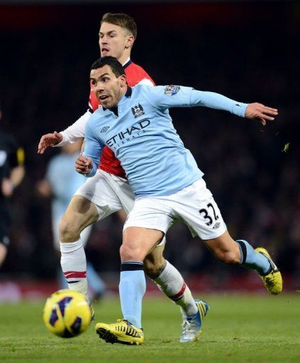 Arsenal&#039;s Aaron Ramsey (back) vies with City&#039;s Carlos Tevez (R) in London on January 13, 2013