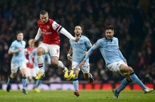 Arsenal&#039;s Lukas Podolski (L) vies with City&#039;s Matija Nastasic (R) in London on January 13, 2013