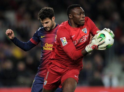 Malaga&#039;s goalkeeper Carlos Kameni vies with Barcelona&#039;s Cesc Fabregas in Barcelona on January 16, 2013