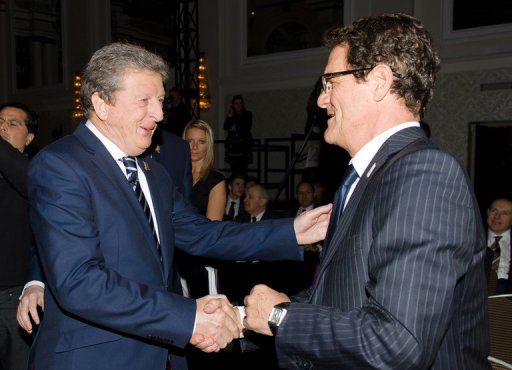 Fabio Capello (R) shakes hands with current England coach Roy Hodgson on January 16, 2013, in London