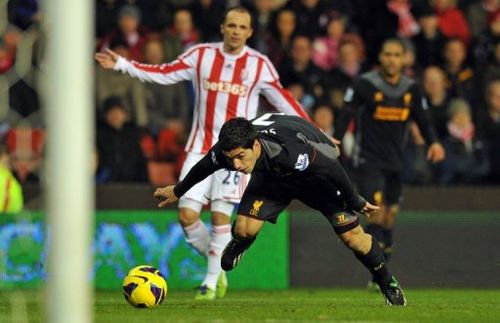 Liverpool's Luis Suarez stumbles as he chases the ball during a league match against Stoke City on December 26, 2012