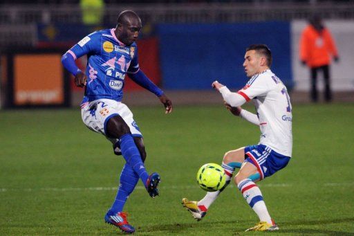 Evian&#039;s forward Yannick Sagbo (L) clashes with Lyon&#039;s forward Anthony Reveillere on January 18, 2013 in Lyon