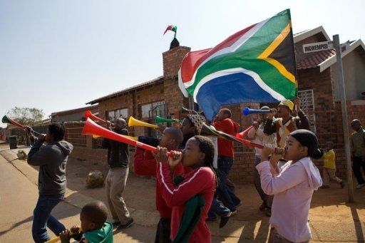 Young people in Soweto blow vuvuzelas on June 10, 2010 before the start of the World Cup