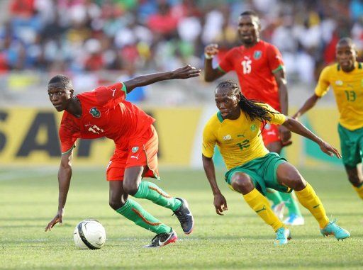Robin Ngalande of Malawi (l) outpaces South Africa&#039;s Renielwe Letsholonyane in a friendly on December 22, 2012 in Durban