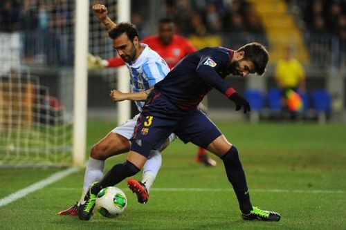 Malaga's defender Jesus Gamez (L) vies with Barcelona's defender Gerard Pique (R) on January 24, 2013.