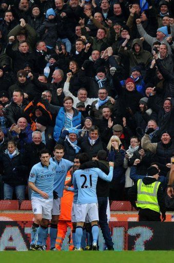 Manchester City&#039;s defender Pablo Zabaleta (unseen) is hugged by a supporter as he celebrates scoring on January 26, 2013